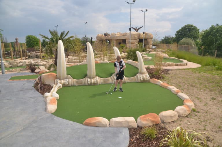 Kid playing mini golf