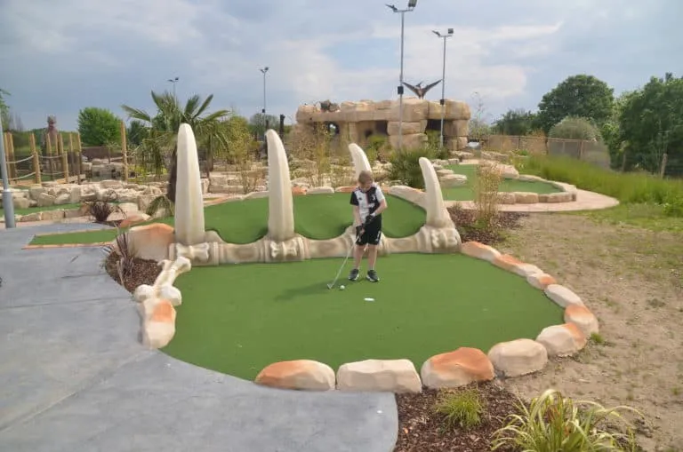 Kid playing mini golf