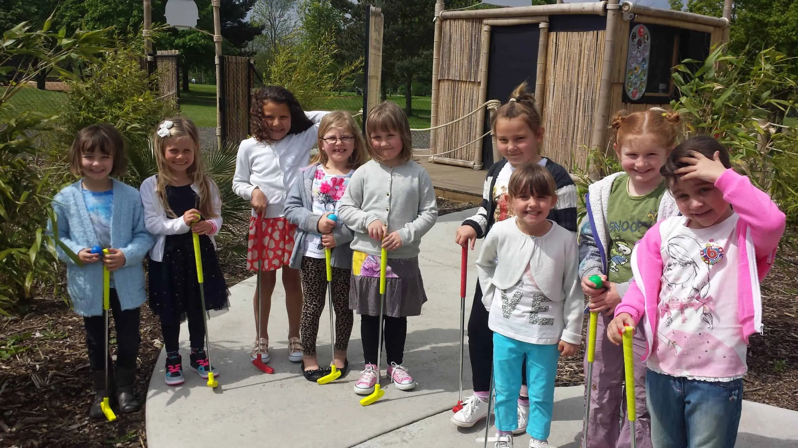 Youngsters holding golf clubs