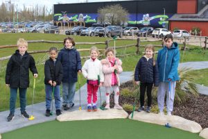 Children posing with small golf clubs