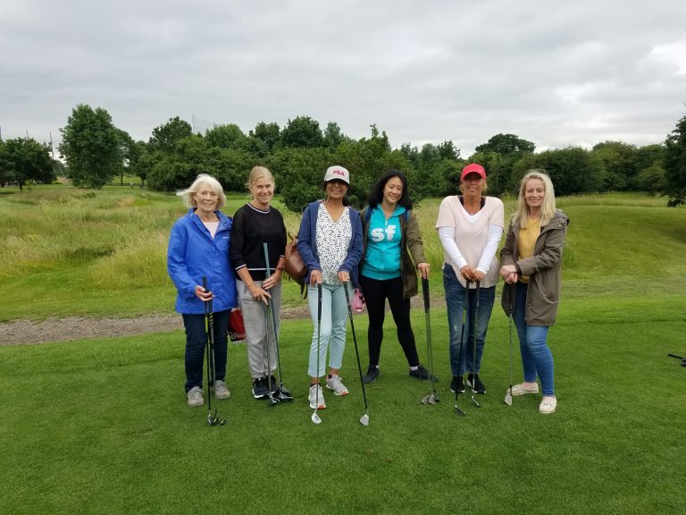 Women golfers posing